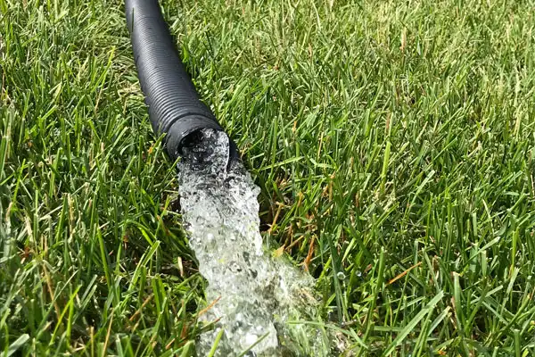 Sump Pump Flowing Water Into Grass
