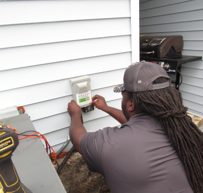 Veteran Air Technician Installing AC Thermostat On Sarasota Home Exterior