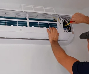 Veteran Air Technician Installing AC Thermostat On Sarasota Home Exterior