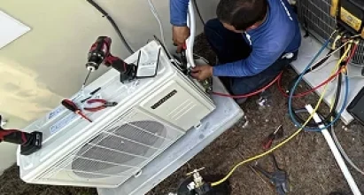 Veteran Air Technician Installing AC Thermostat On Sarasota Home Exterior