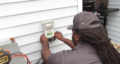 Veteran Air Technician Installing AC Thermostat On Sarasota Home Exterior