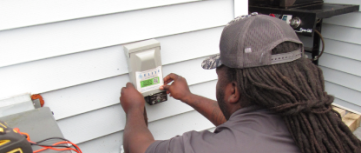 Veteran Air Technician Installing AC Thermostat On Sarasota Home Exterior