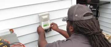 Veteran Air Technician Installing AC Thermostat On Sarasota Home Exterior