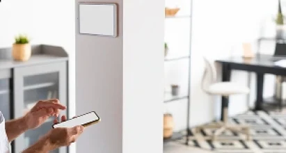 Veteran Air Technician Installing AC Thermostat On Sarasota Home Exterior