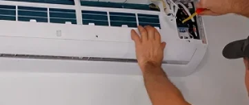 Veteran Air Technician Installing AC Thermostat On Sarasota Home Exterior