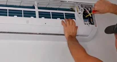 Veteran Air Technician Installing AC Thermostat On Sarasota Home Exterior
